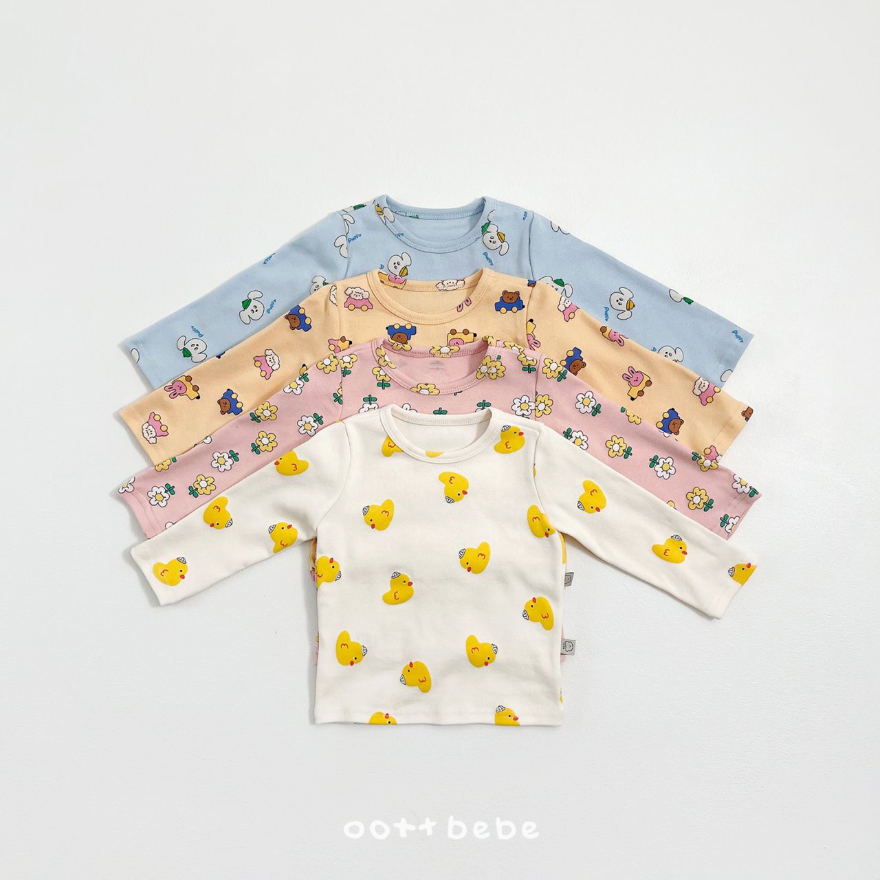 oott bebe 春季印花長袖上衣系列一字排開，展示藍色狗狗、米色小熊、粉色花朵與白色小鴨四種可愛款式。