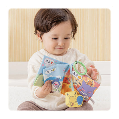 寶寶在家中閱讀 Monpoké 布書，雙手翻閱訓練小肌肉