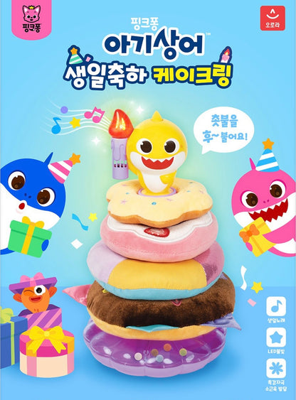 Baby Shark 生日蛋糕疊疊樂玩具海報，黃色鯊魚公仔手持發光蠟燭站在四層冬甩蛋糕上，背景有鯊魚爸爸媽媽及禮物盒，充滿生日派對氣氛。