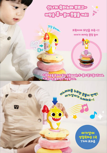 幼兒示範 Baby Shark 玩具玩法，圖解展示對著蠟燭吹氣可熄滅燈光，以及按壓鯊魚背鰭會播放生日歌及閃爍 LED 燈光的功能。
