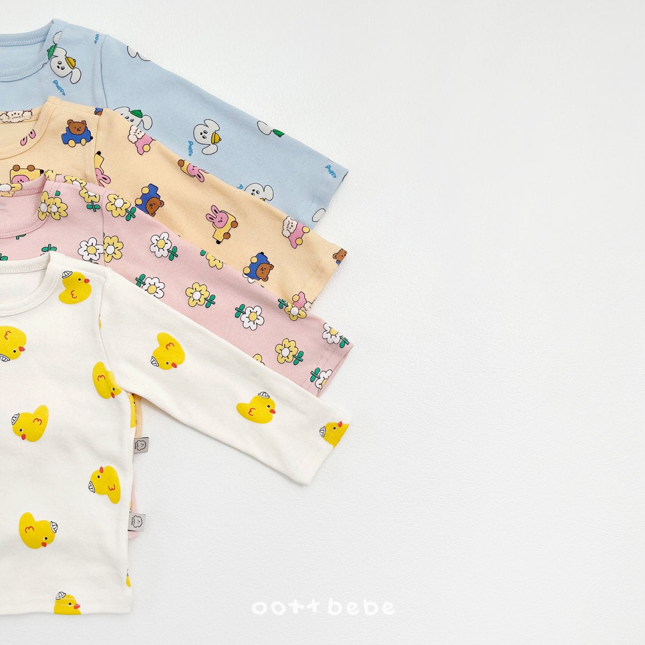 韓國童裝 oott bebe 四款花色領口細節特寫，近距離展示柔軟棉質布料質感與精緻包邊工藝。